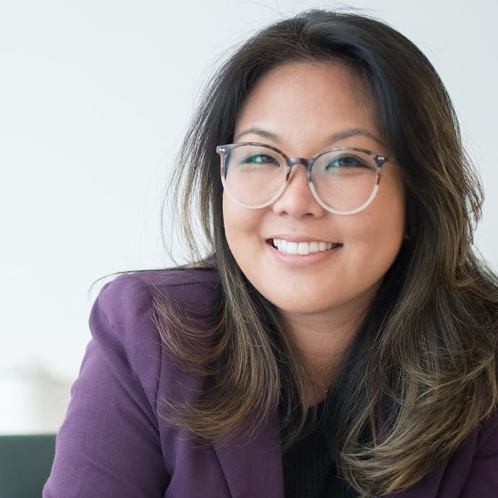 a woman sitting on a table with potted plant